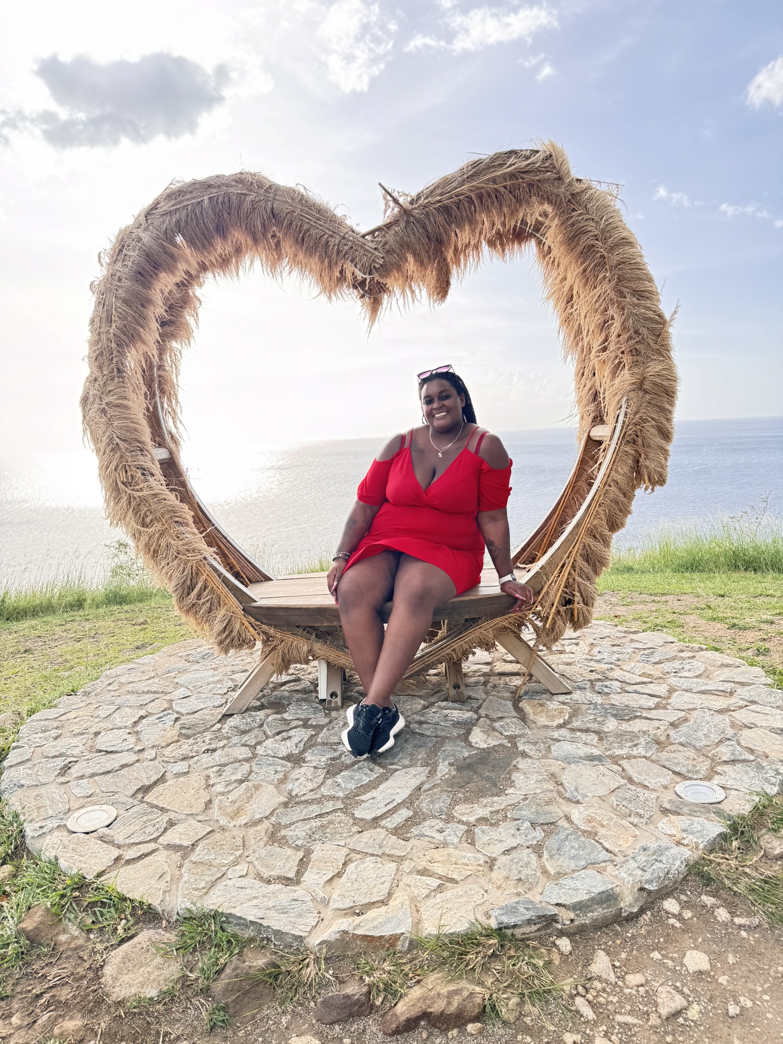 Voyageuse avec son carnet face à une ville côtière parmi ses destinations préférées